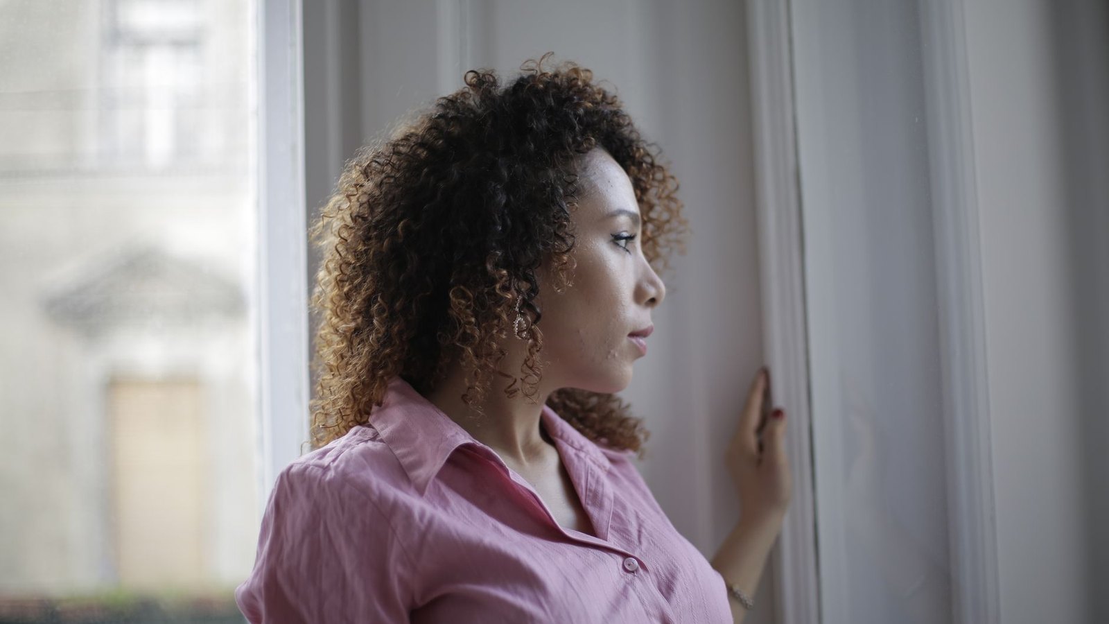 A thoughtful woman gazing out a window, conveying a muted, flat mood that an antidepressant cannot fully resolve.